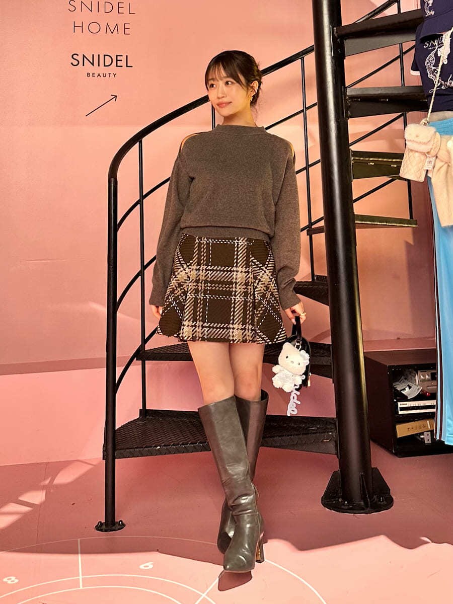 ブラウン系のニット/セーター、ブラウン系のスカート、グレー系のブーツを着用したレディースの秋コーディネートの2枚目の写真