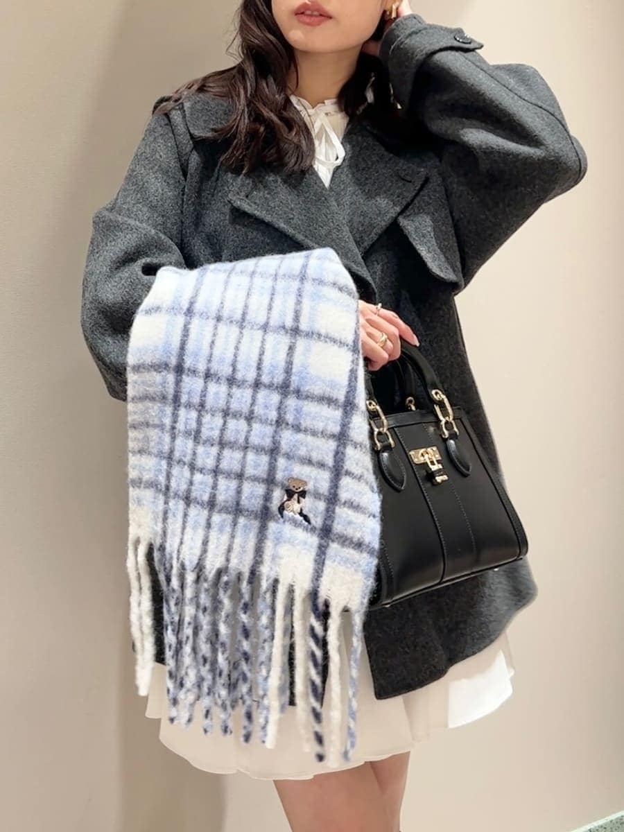 ホワイト系のワンピース、ブラック系のハンドバッグ、ブルー系のマフラーを着用したレディースの冬コーディネートの5枚目の写真