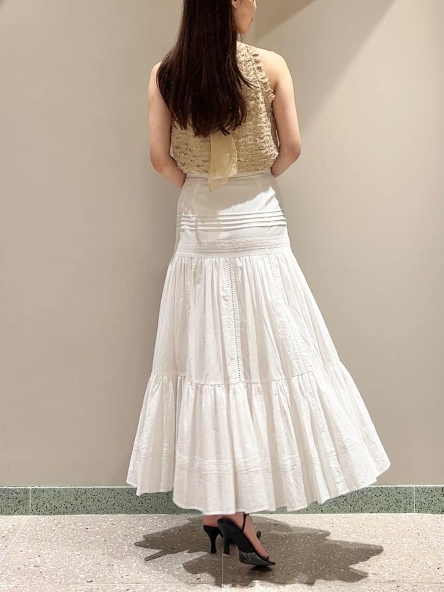 イエロー系のTシャツ/カットソー、ホワイト系のスカート、ブラック系のショルダーバッグを着用したレディースの夏コーディネートの2枚目の写真