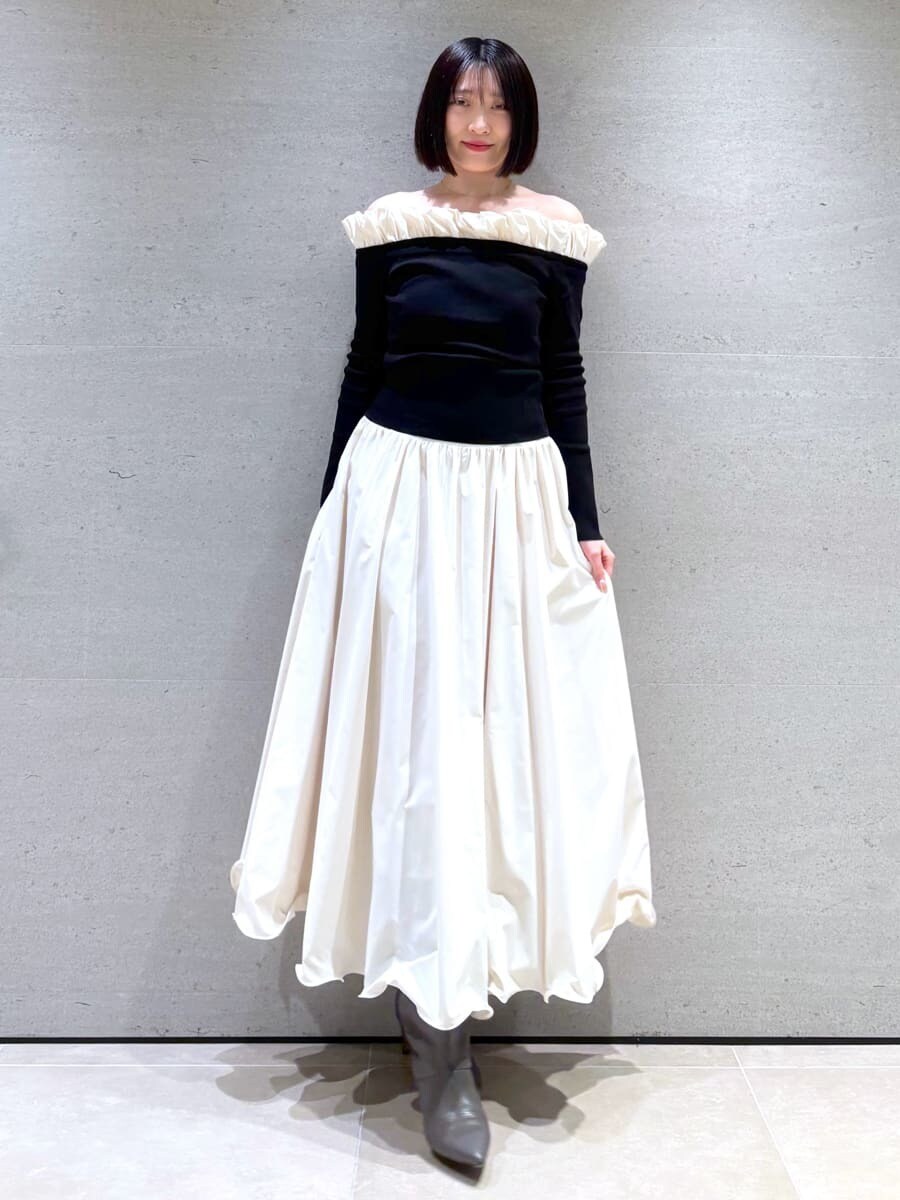 ホワイト系のスカート、ブラック系のニット/セーターを着用したレディースの冬コーディネートの2枚目の写真