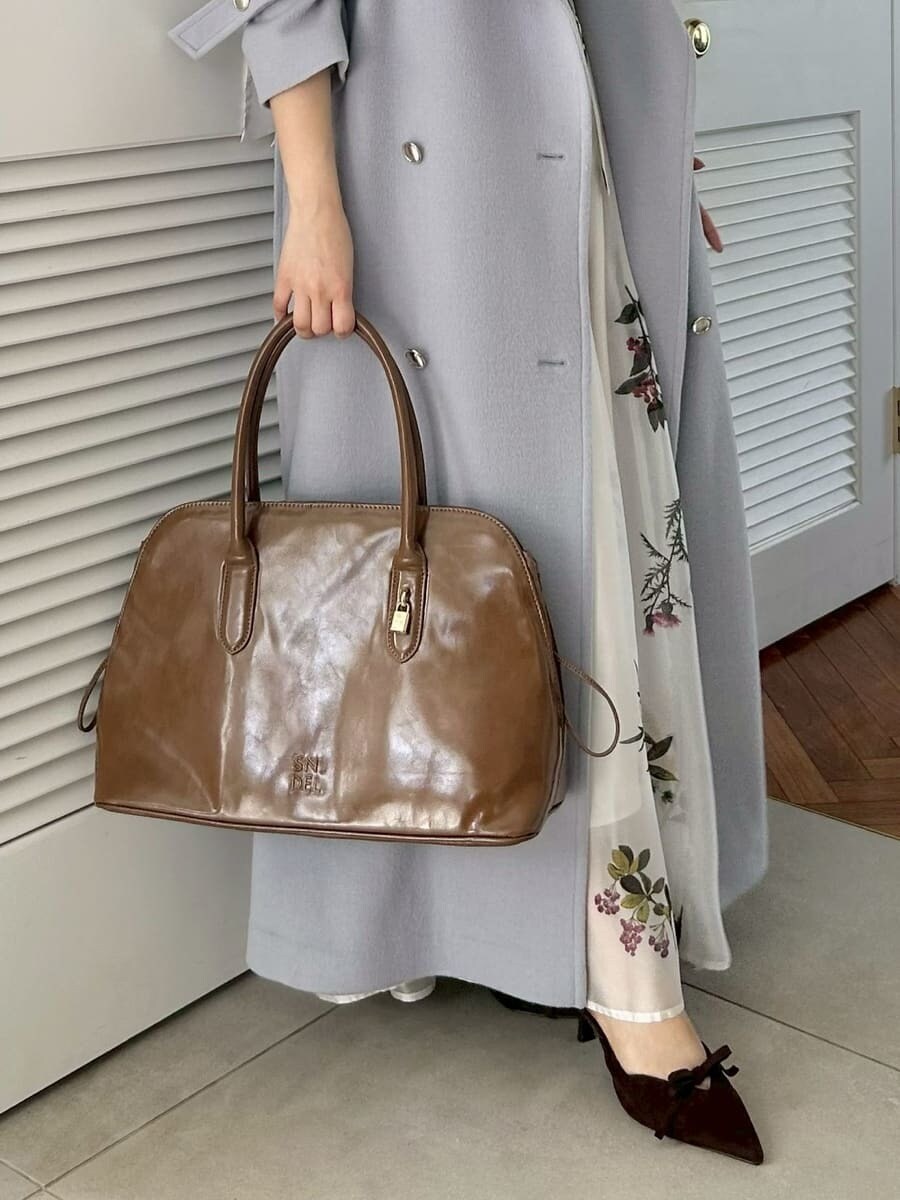 ブラウン系のハンドバッグを着用したレディースの秋コーディネートの6枚目の写真