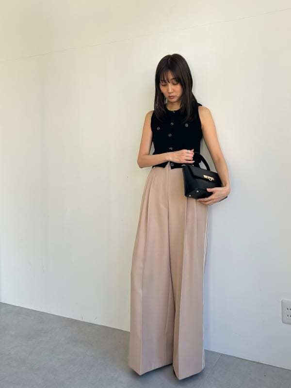 ブラック系のニット/セーター、ベージュ系のその他パンツ、ブラック系のショルダーバッグを着用したレディースの春コーディネートの5枚目の写真