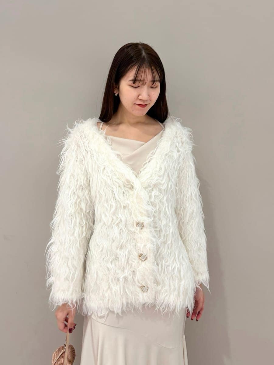 ホワイト系のワンピース、ホワイト系のカーディガン/ボレロ、その他のイヤリングを着用したレディースの冬コーディネートの3枚目の写真