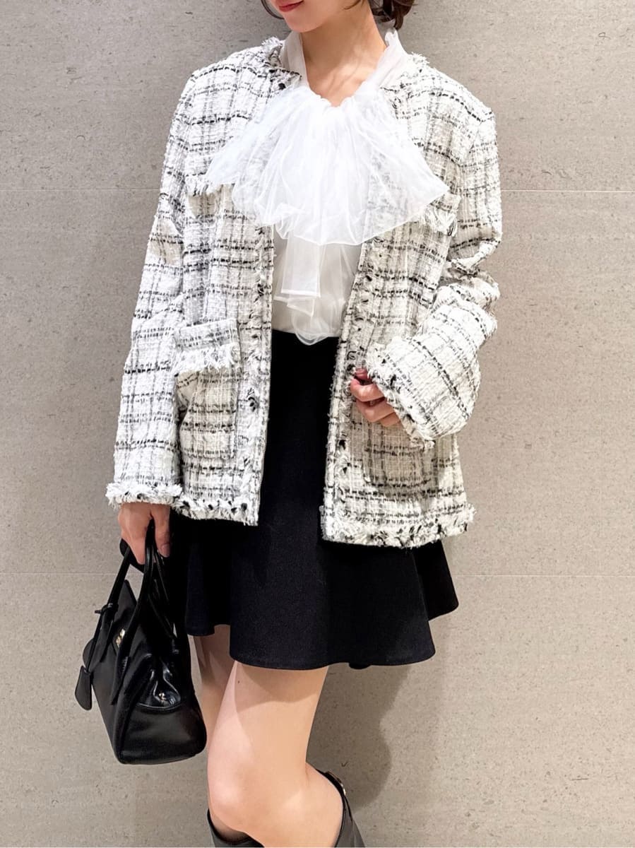 ブラック系のボストンバッグ、ホワイト系のノーカラージャケット、ブラック系のその他パンツを着用したレディースの冬コーディネートの3枚目の写真