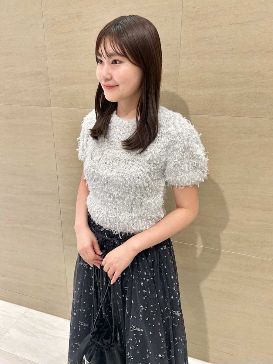 ブルー系のスカート、グレー系のニット/セーター、ブラック系のハンドバッグを着用したレディースの秋コーディネートの5枚目の写真