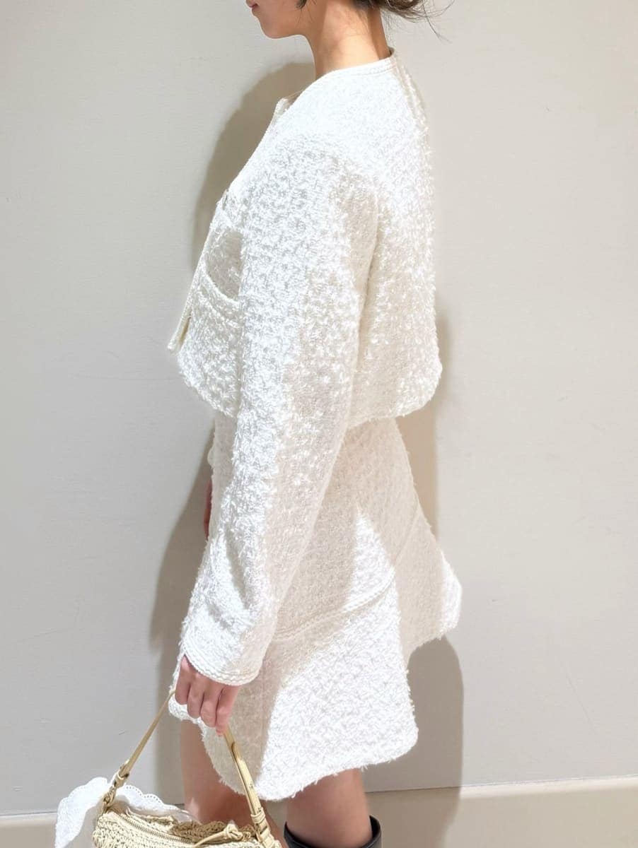 ブラウン系のブーツ、ホワイト系のノーカラージャケット、ホワイト系のスカートを着用したレディースの冬コーディネートの3枚目の写真