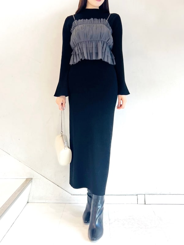 ブラック系のワンピース、ブラック系のブーツ、ベージュ系のショルダーバッグを着用したレディースの秋コーディネートの2枚目の写真