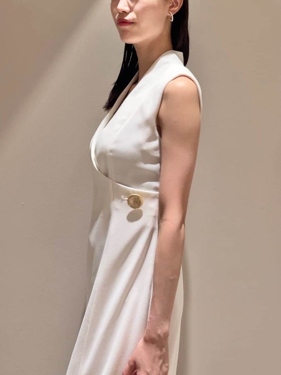 ホワイト系のワンピース、イエロー系のローファー、ベージュ系のショルダーバッグを着用したレディースの夏コーディネートの4枚目の写真