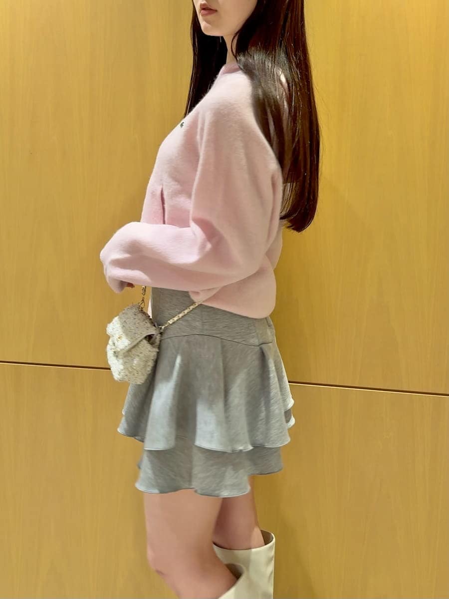 ホワイト系のショルダーバッグ、ピンク系のニット/セーター、ホワイト系のブーツを着用したレディースの冬コーディネートの2枚目の写真