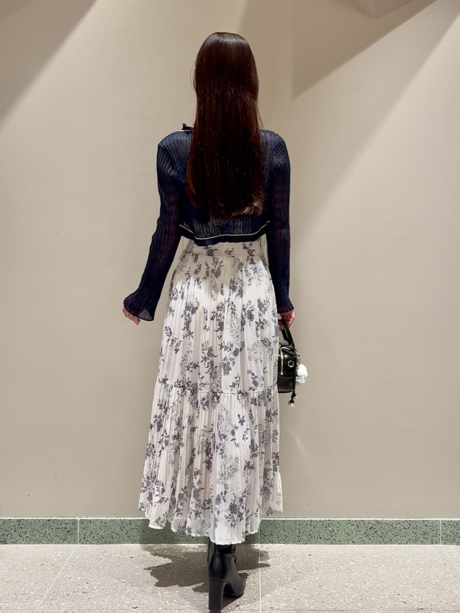 ホワイト系のワンピース、ブルー系のカーディガン/ボレロ、ブラック系のブーツを着用したレディースの秋コーディネートの2枚目の写真