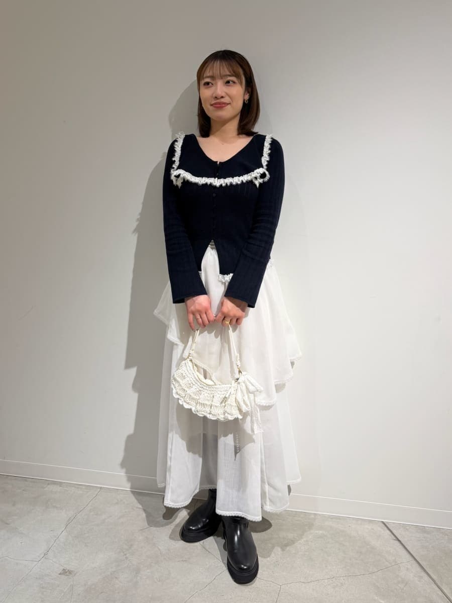 ブラック系のブーツ、ホワイト系のスカート、ブルー系のニット/セーターを着用したレディースの冬コーディネートの2枚目の写真