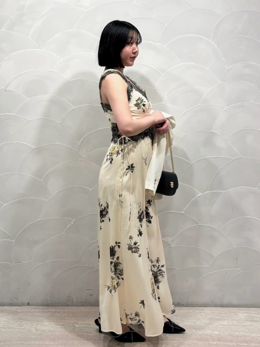 ホワイト系のテーラードジャケット、イエロー系のワンピース、ブラック系のパンプスを着用したレディースの春コーディネートの2枚目の写真