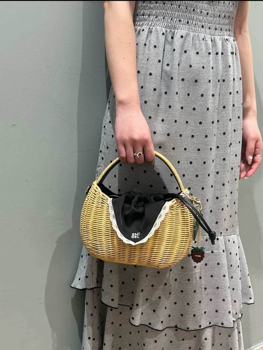 ブラック系のかごバッグ、グレー系のワンピースを着用したレディースの春コーディネートの7枚目の写真