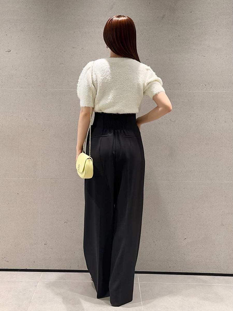 ブラック系のその他パンツ、ホワイト系のニット/セーター、ブラウン系のサンダルを着用したレディースの春コーディネートの2枚目の写真