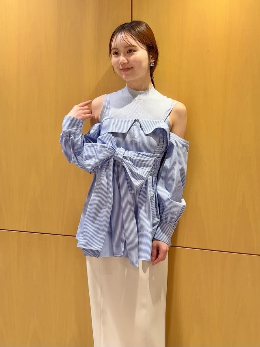 ホワイト系のスカート、ブルー系のニット/セーター、ベージュ系のハンドバッグを着用したレディースの冬コーディネートの4枚目の写真