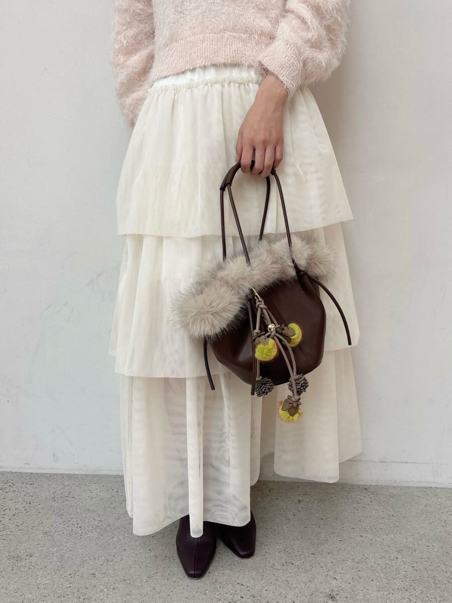 レッド系のブーツ、グレー系のチェスターコート、ホワイト系のスカートを着用したレディースの冬コーディネートの10枚目の写真