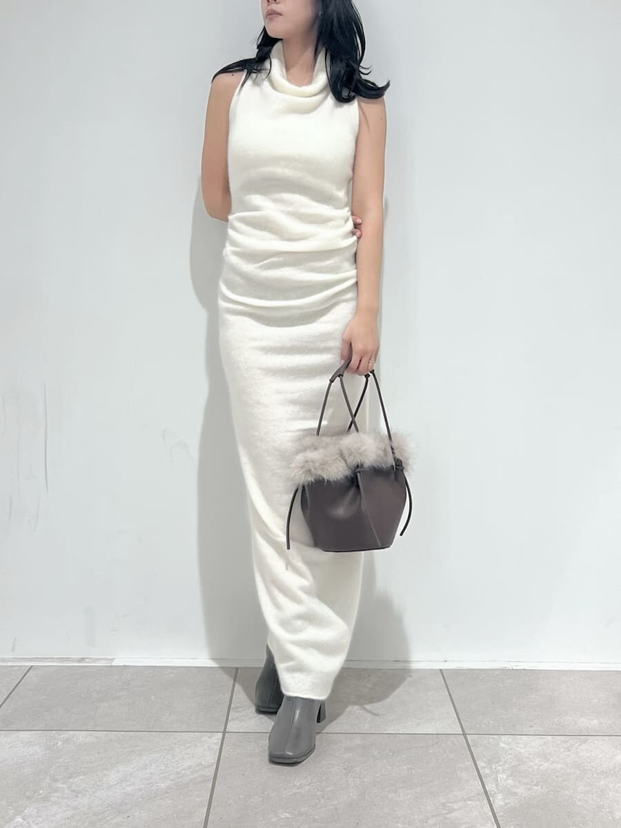 ホワイト系のチェスターコート、ホワイト系のワンピース、ブラウン系のハンドバッグを着用したレディースの冬コーディネートの5枚目の写真