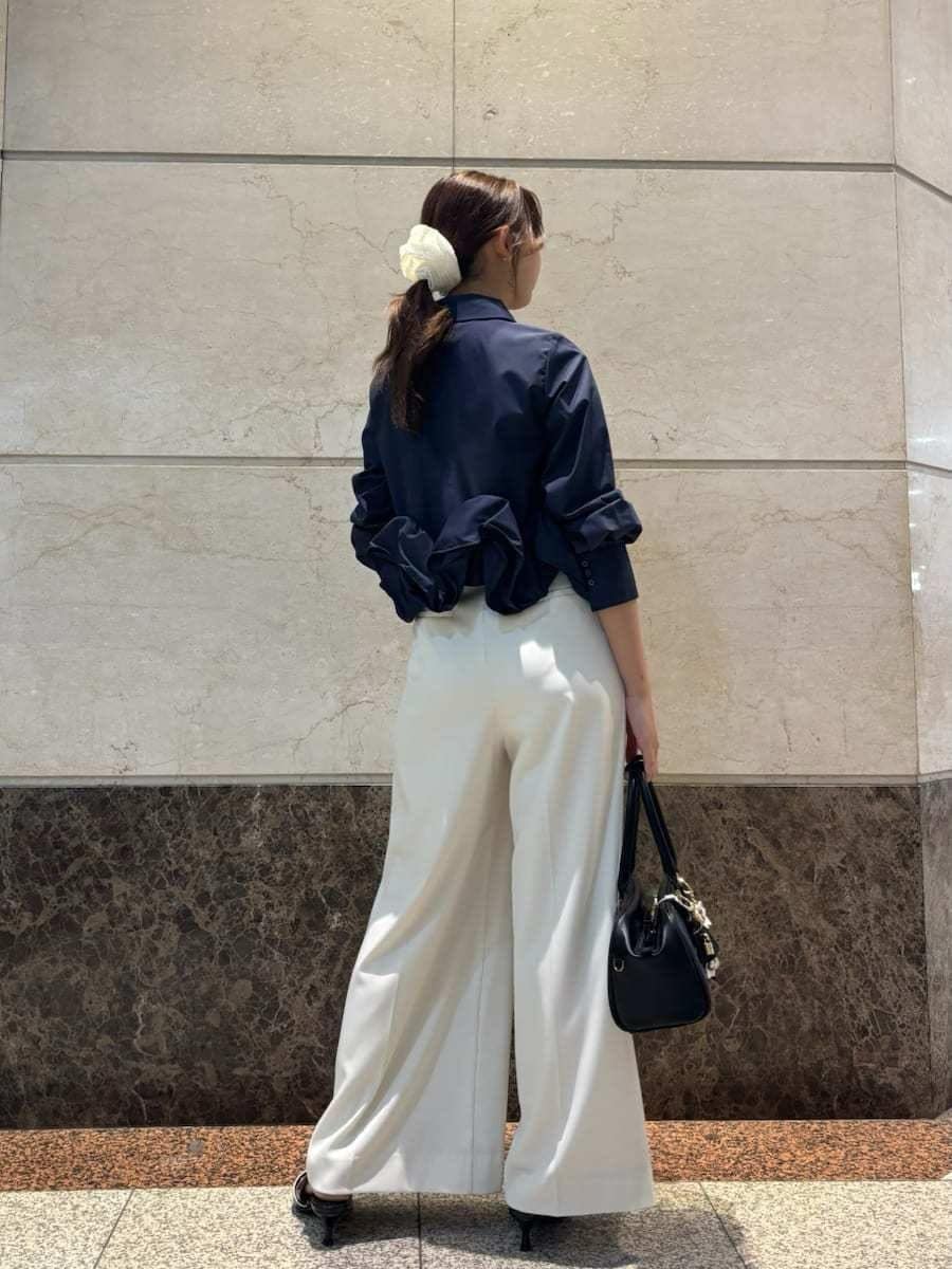 ホワイト系のその他パンツ、ブルー系のシャツ/ブラウス、ブラック系のパンプスを着用したレディースの冬コーディネートの6枚目の写真