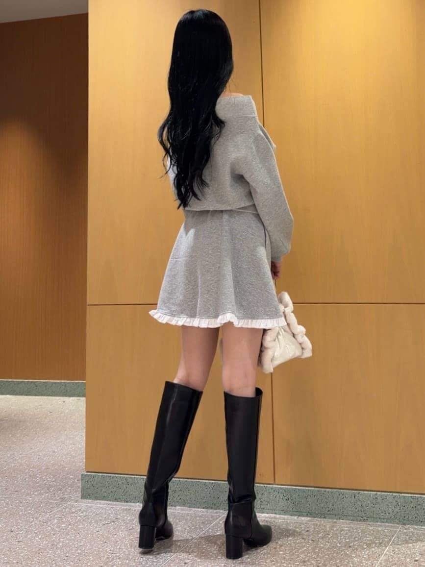 グレー系のワンピース、ブラック系のブーツ、ホワイト系のショルダーバッグを着用したレディースの秋コーディネートの5枚目の写真