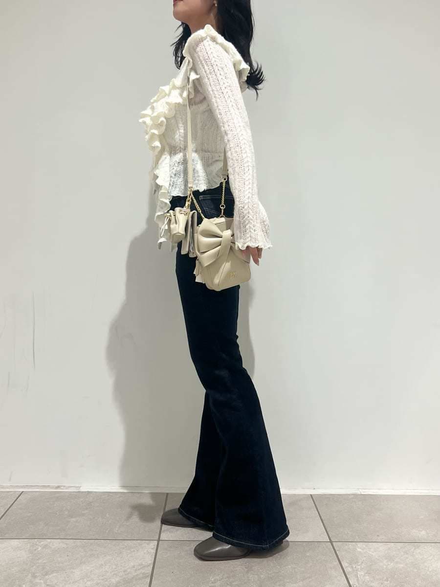 ブルー系のその他パンツ、ホワイト系のニット/セーター、ホワイト系のショルダーバッグを着用したレディースの冬コーディネートの6枚目の写真