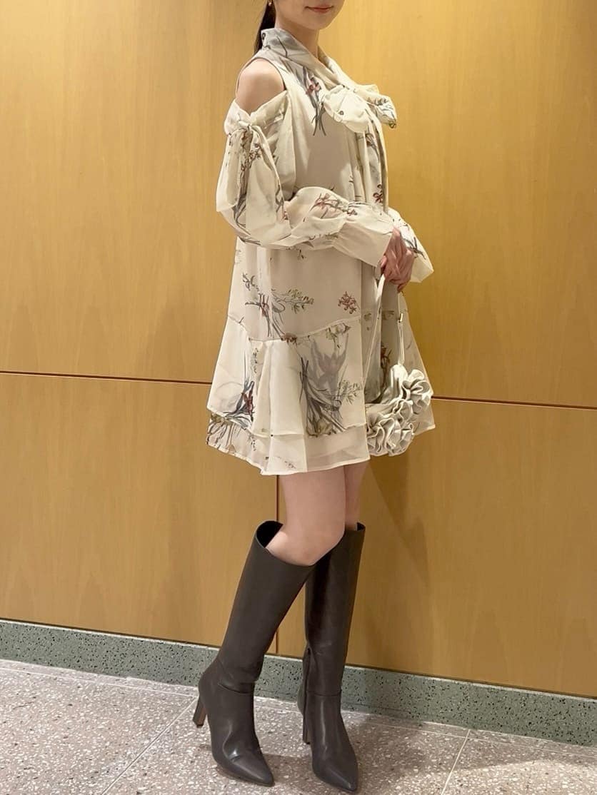 グレー系のブーツ、イエロー系のワンピース、ホワイト系のハンドバッグを着用したレディースの冬コーディネートの4枚目の写真