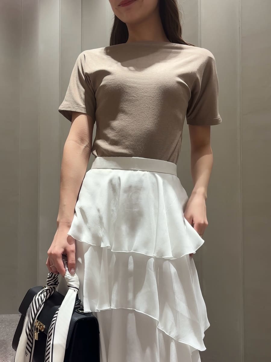 ブラック系のハンドバッグ、ホワイト系のスカート、ベージュ系のTシャツ/カットソーを着用したレディースの夏コーディネートの4枚目の写真