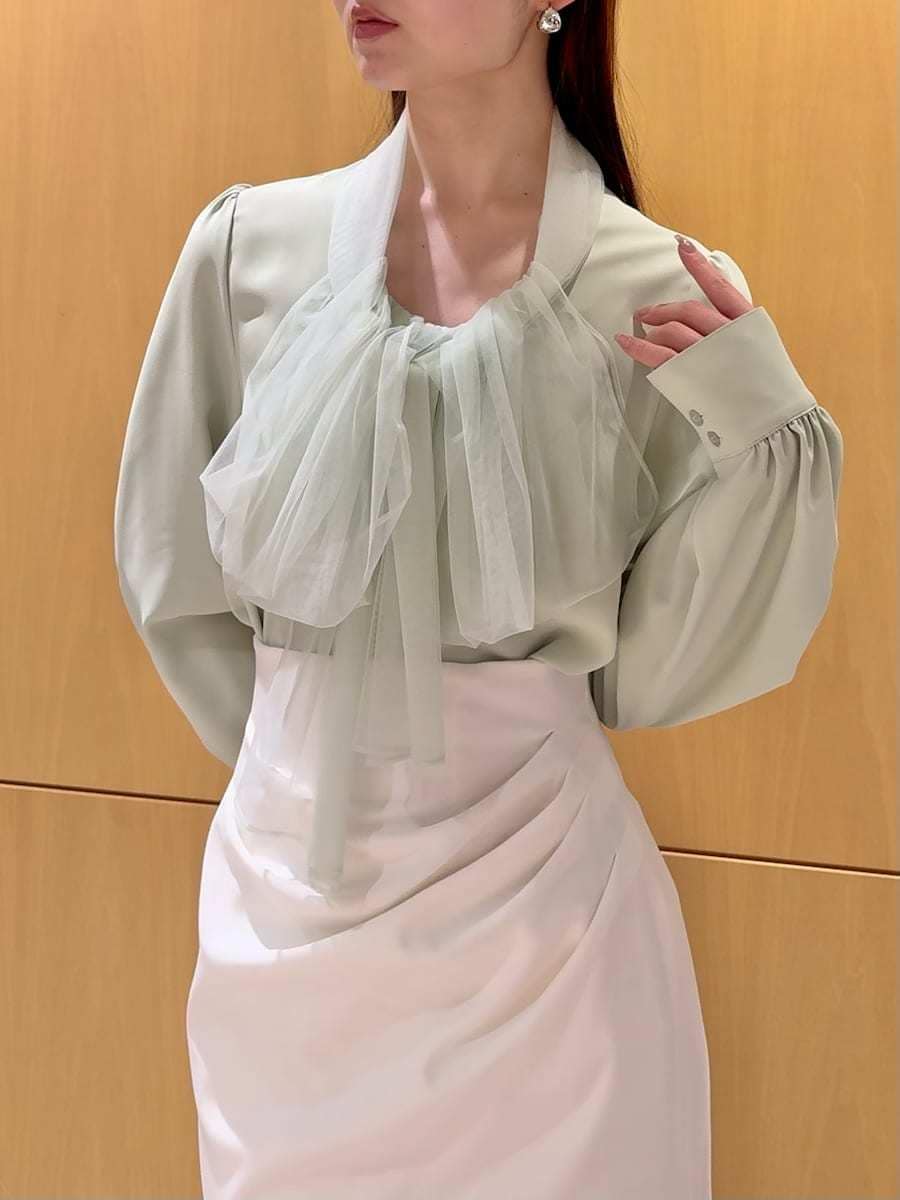 ブラック系のブーツ、ホワイト系のトレンチコート、ホワイト系のスカートを着用したレディースの冬コーディネートの9枚目の写真