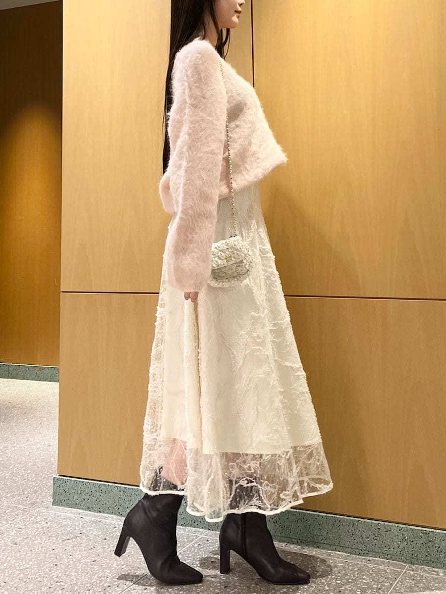 レッド系のブーツ、ホワイト系のショルダーバッグ、ピンク系のニット/セーターを着用したレディースの冬コーディネートの5枚目の写真