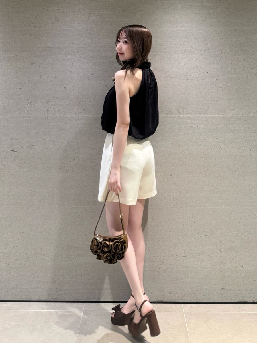 ブラウン系のハンドバッグ、ホワイト系のその他パンツ、ブラック系のTシャツ/カットソーを着用したレディースの夏コーディネートの2枚目の写真