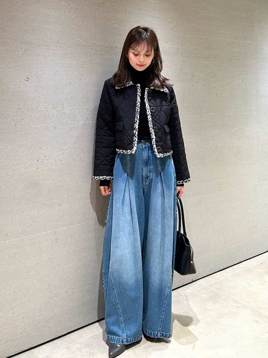 ブルー系のデニムパンツ、ブラック系のテーラードジャケット、ブラック系のニット/セーターを着用したレディースの秋コーディネートの3枚目の写真