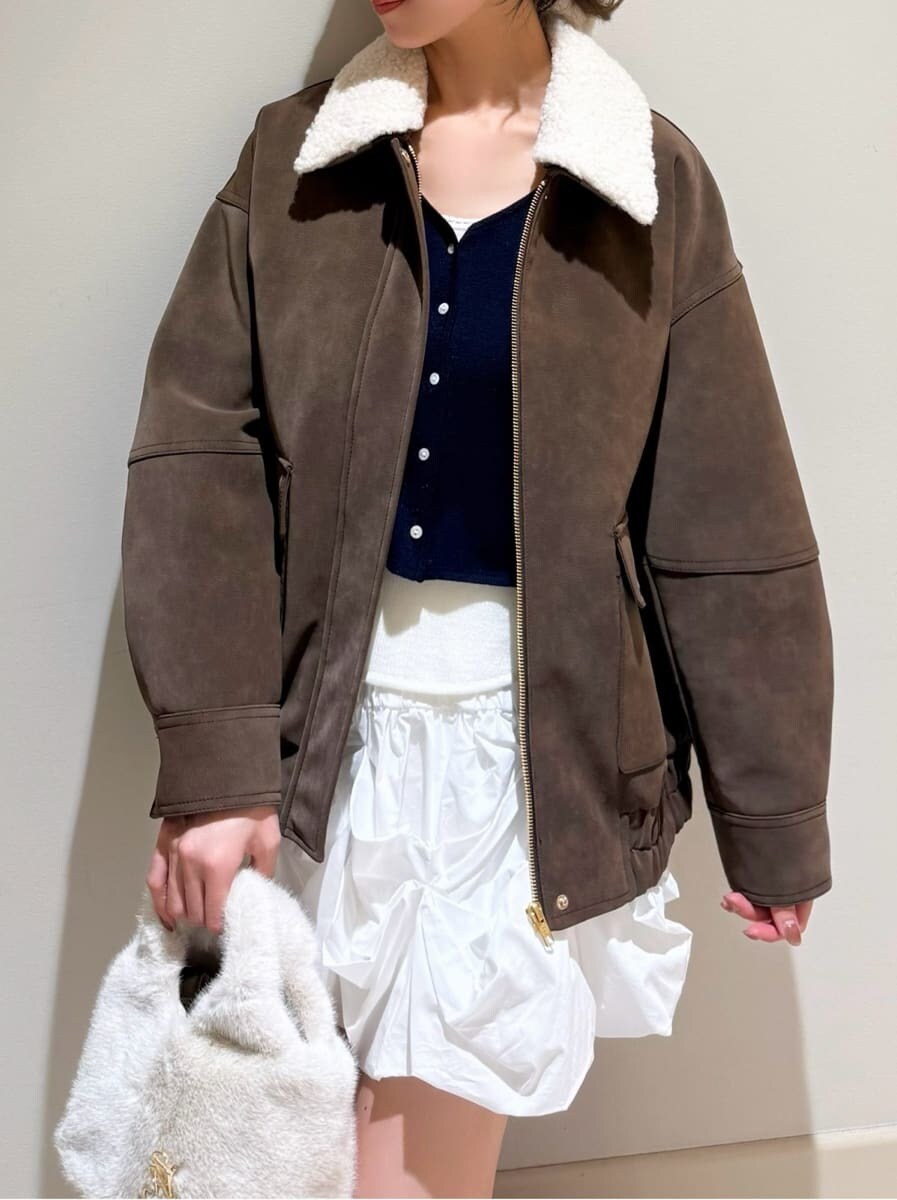 ブラック系のブーツ、ブラウン系のブルゾン、ホワイト系のその他パンツを着用したレディースの秋コーディネートの5枚目の写真