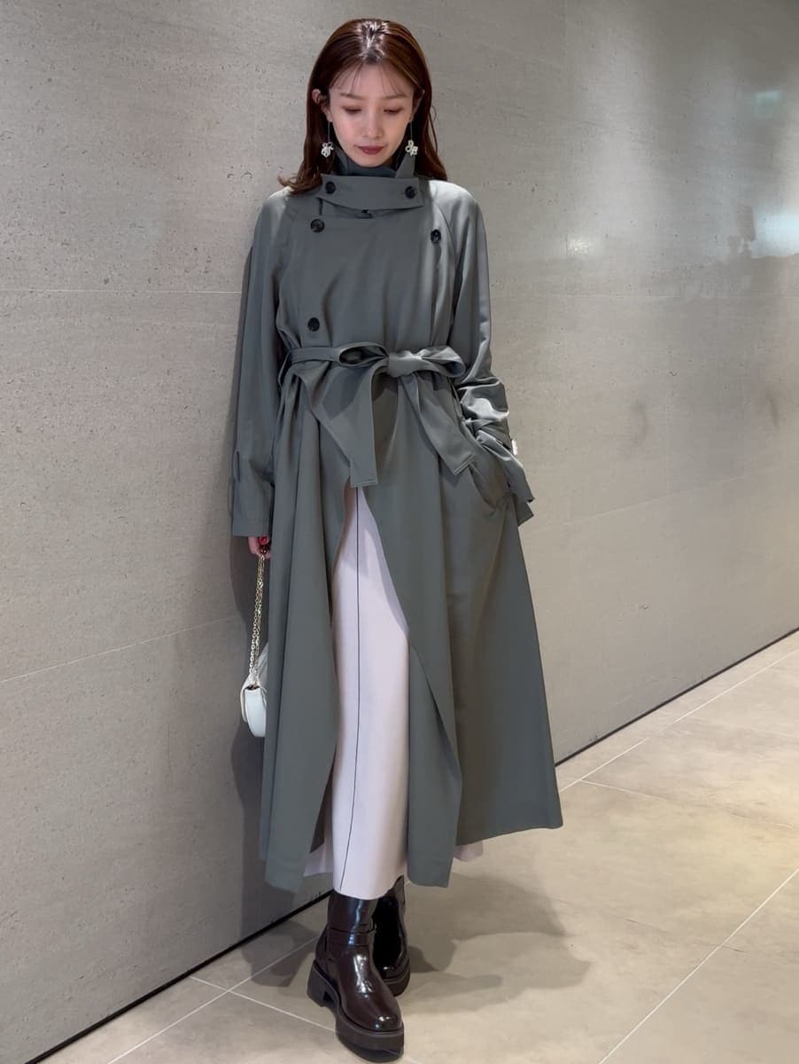 ホワイト系のワンピース、グリーン系のトレンチコート、ホワイト系のショルダーバッグを着用したレディースの冬コーディネートの6枚目の写真