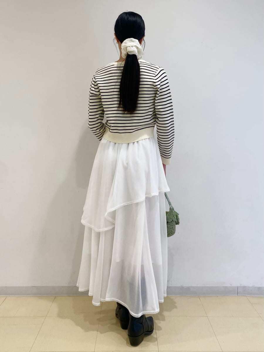 ブラック系のパンプス、ホワイト系のスカート、その他のニット/セーターを着用したレディースの冬コーディネートの2枚目の写真