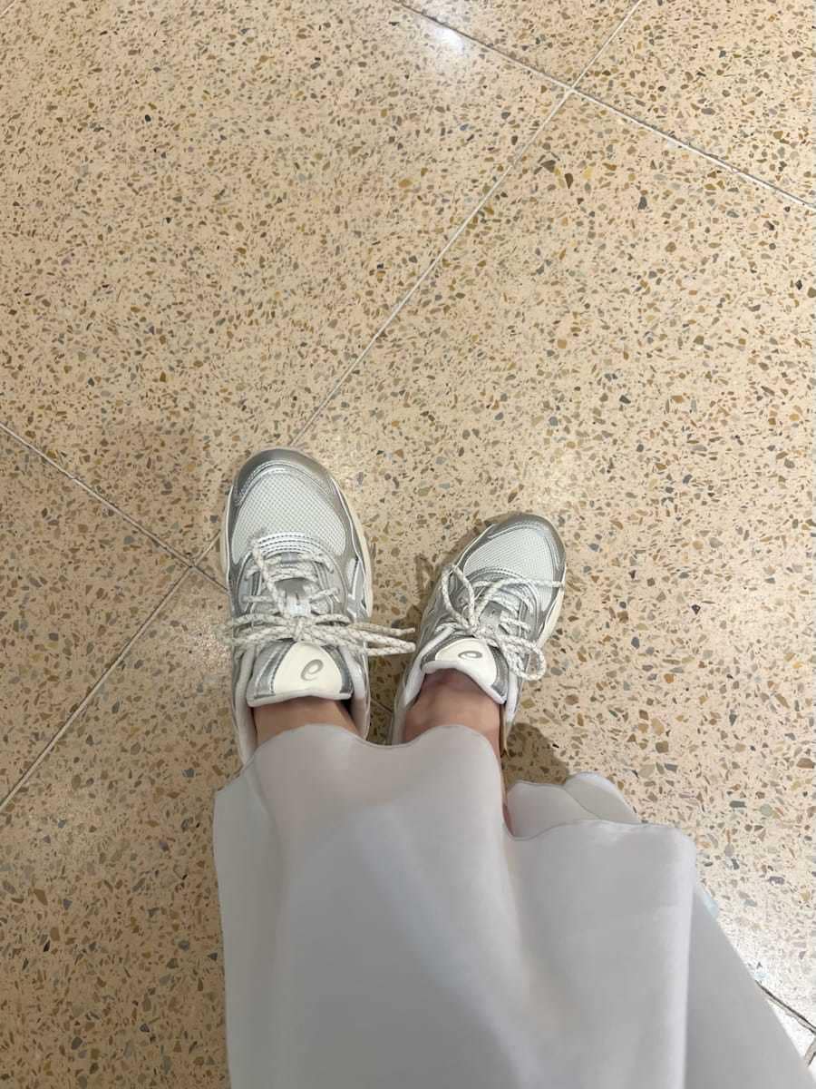 ブルー系のワンピース、ホワイト系のショルダーバッグ、シルバー系のスニーカーを着用したレディースの冬コーディネートの7枚目の写真