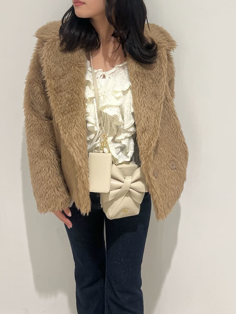 ブルー系のその他パンツ、ホワイト系のニット/セーター、ホワイト系のショルダーバッグを着用したレディースの冬コーディネートの4枚目の写真