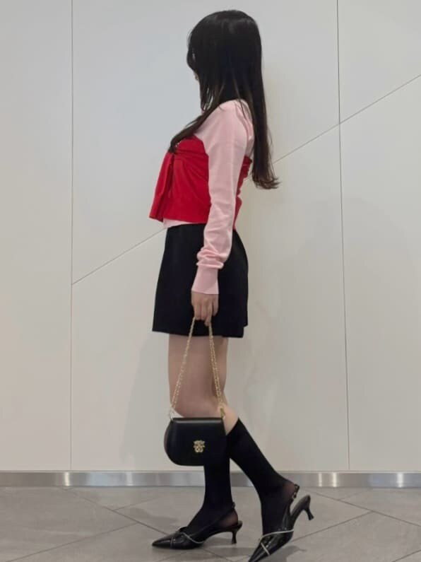 レッド系のカーディガン/ボレロ、ブラック系のパンプス、ブラック系のショルダーバッグを着用したレディースの冬コーディネートの3枚目の写真