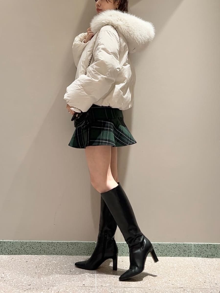 ブラック系のブーツ、ブラック系のショルダーバッグ、ホワイト系のダウンジャケット/コートを着用したレディースの冬コーディネートの5枚目の写真