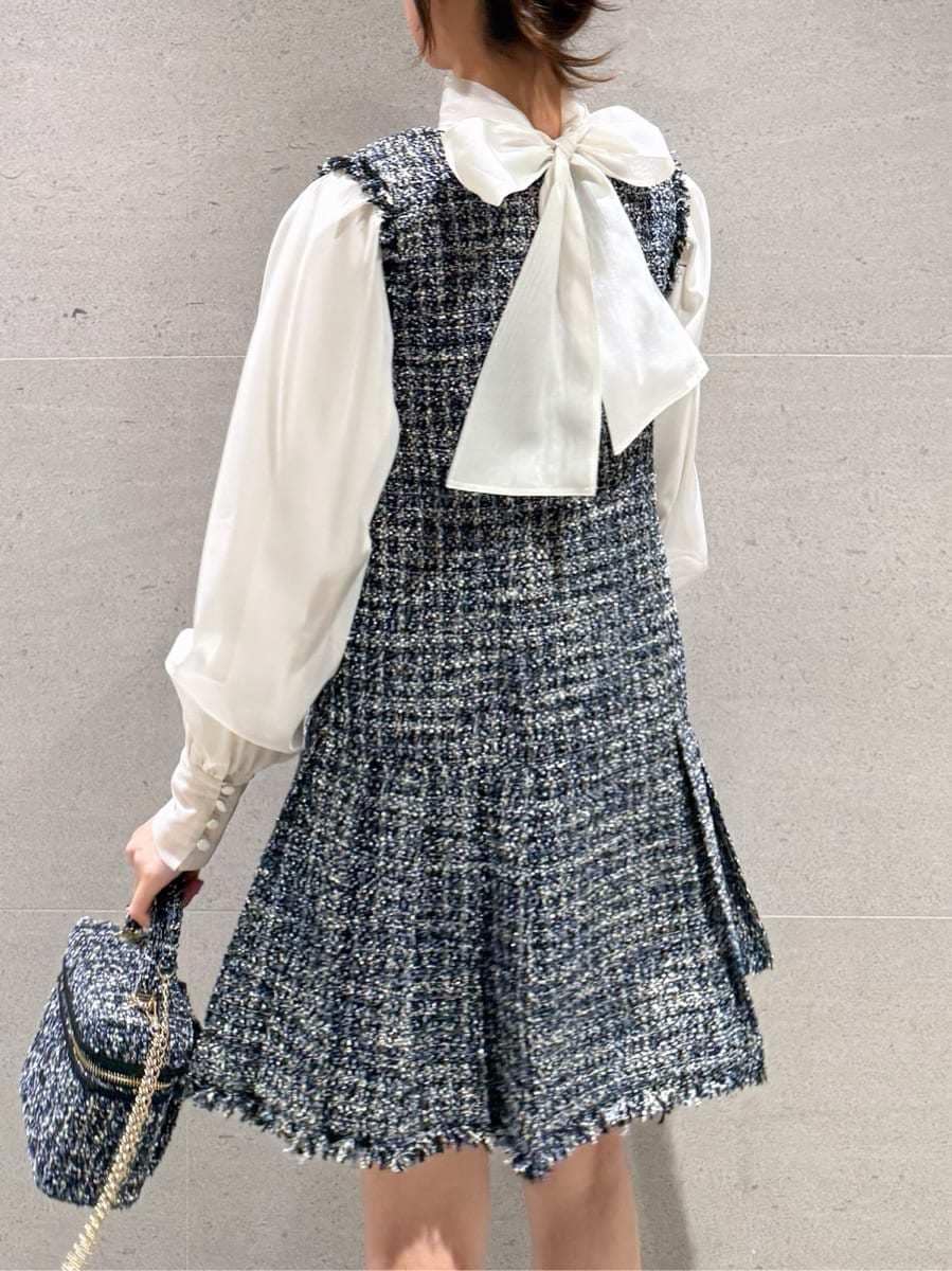 ブルー系のワンピース、ブルー系のハンドバッグ、その他のイヤリングを着用したレディースの冬コーディネートの5枚目の写真