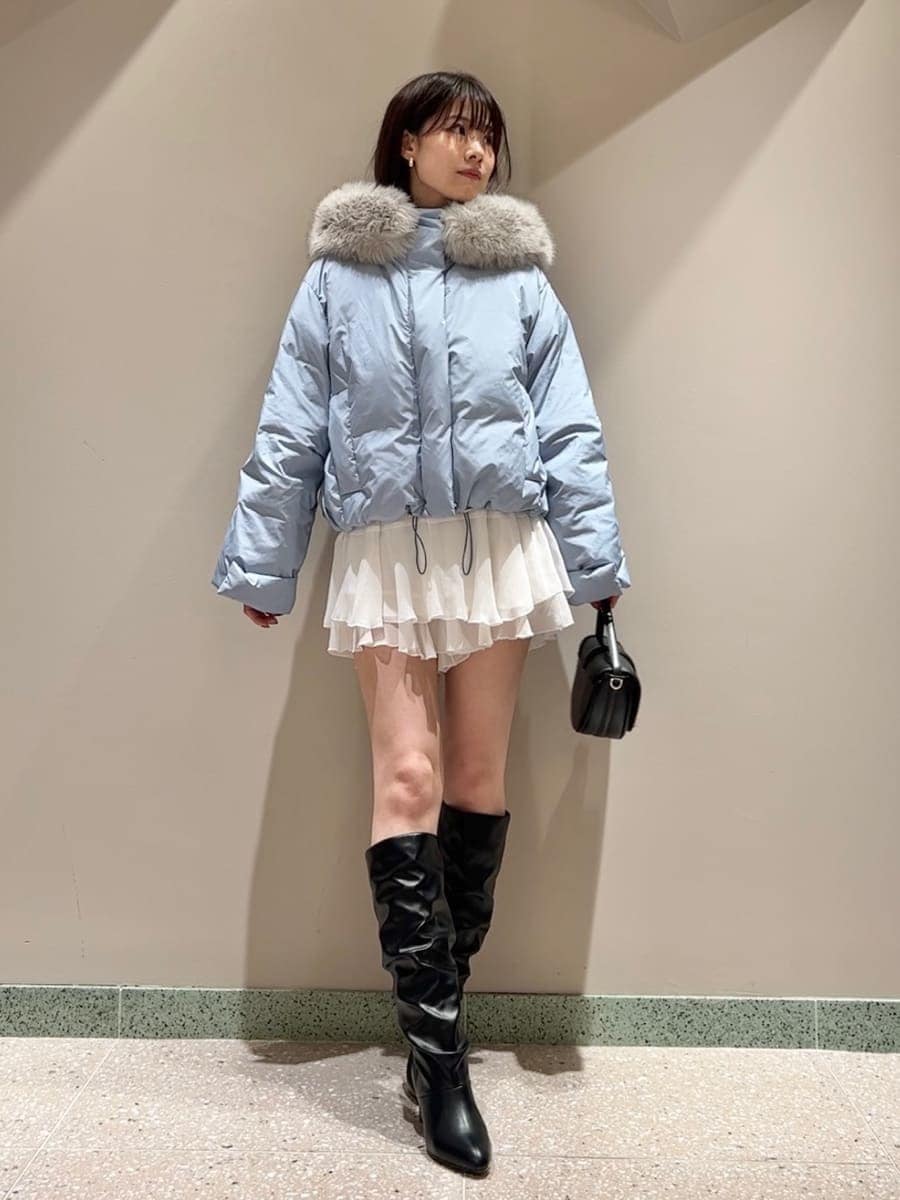 ブラック系のハンドバッグ、ブルー系のダウンジャケット/コート、ホワイト系のその他パンツを着用したレディースの秋コーディネートの2枚目の写真