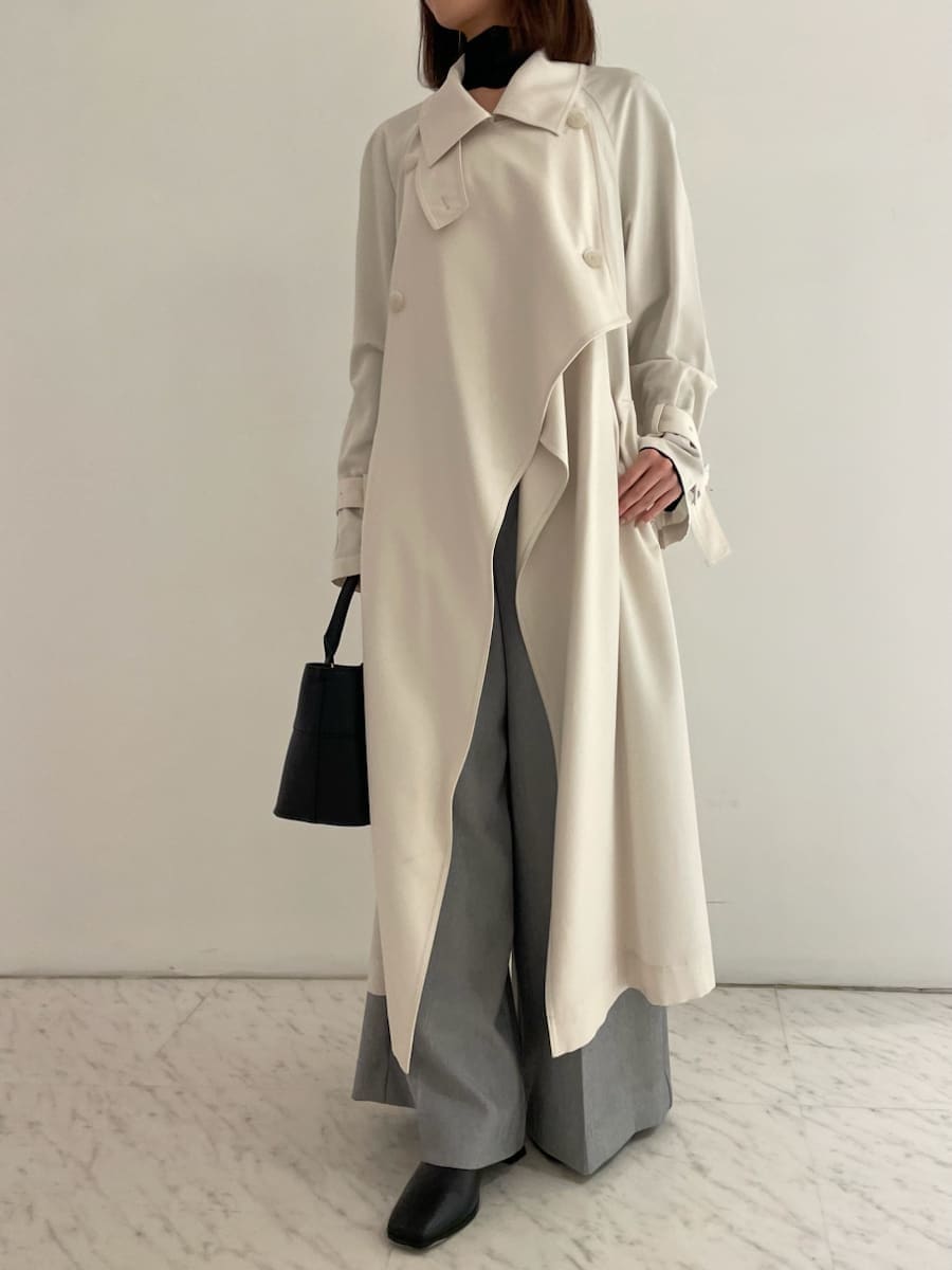 ブラック系のショルダーバッグ、ブラック系のニット/セーター、ホワイト系のトレンチコートを着用したレディースの冬コーディネートの6枚目の写真