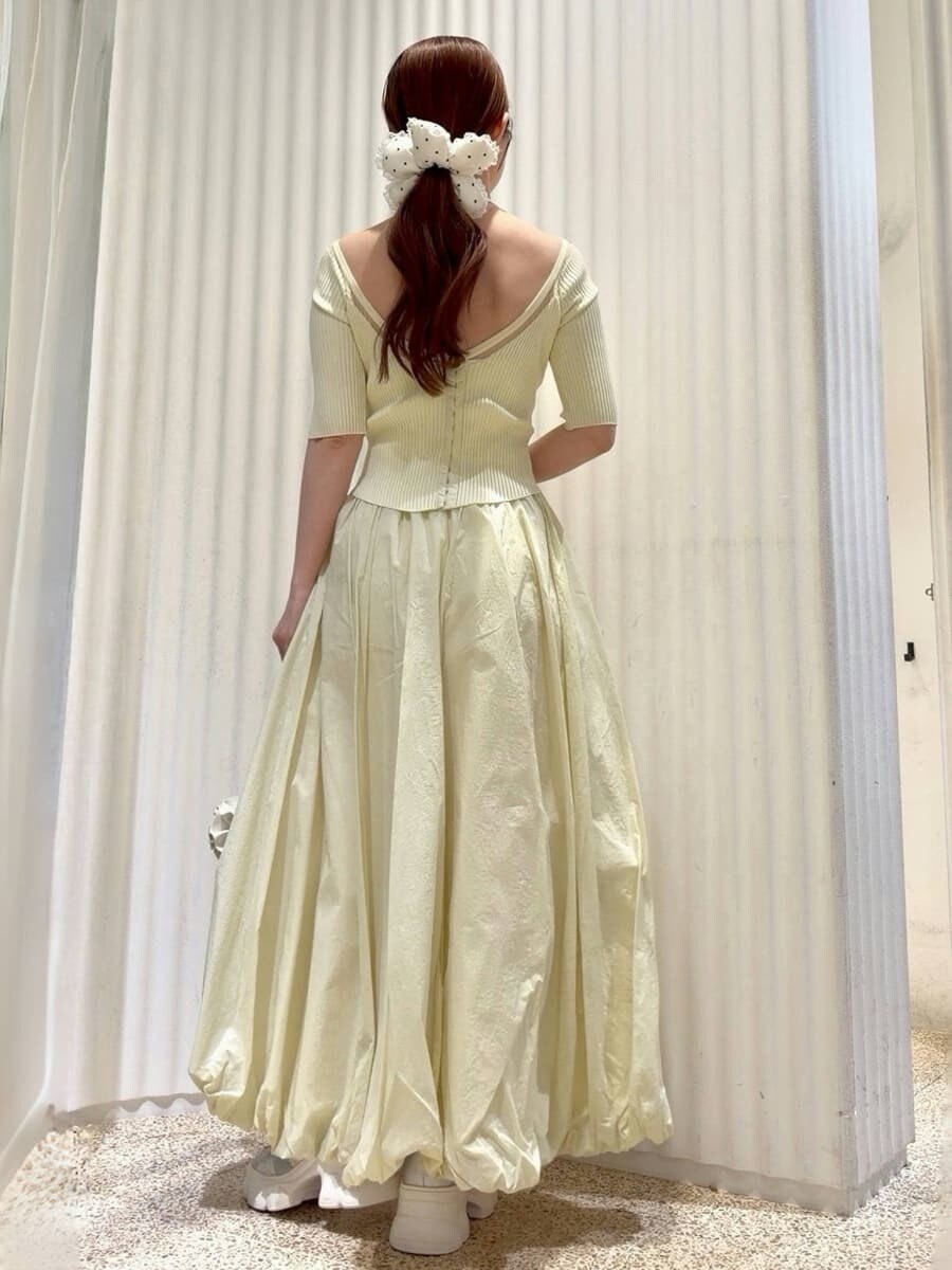 ホワイト系のハンドバッグ、ホワイト系のパンプス、ゴールド系のイヤリングを着用したレディースの春コーディネートの6枚目の写真