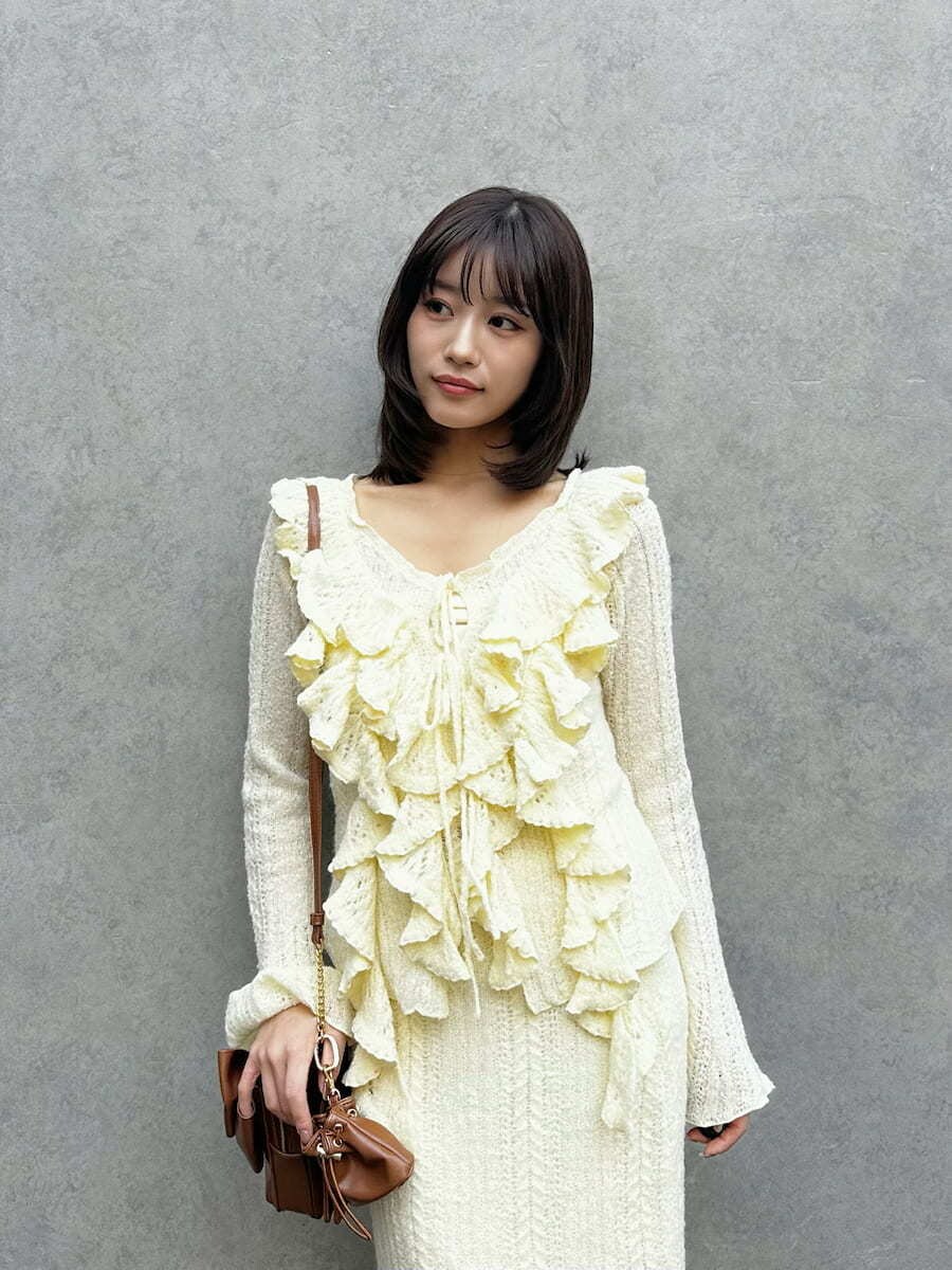 グレー系のブーツ、イエロー系のスカート、イエロー系のニット/セーターを着用したレディースの秋コーディネートの2枚目の写真