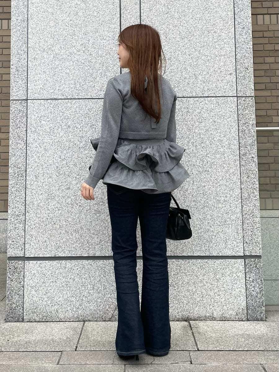 シルバー系のニット/セーター、シルバー系のカーディガン/ボレロ、ブルー系のデニムパンツを着用したレディースの春コーディネートの2枚目の写真