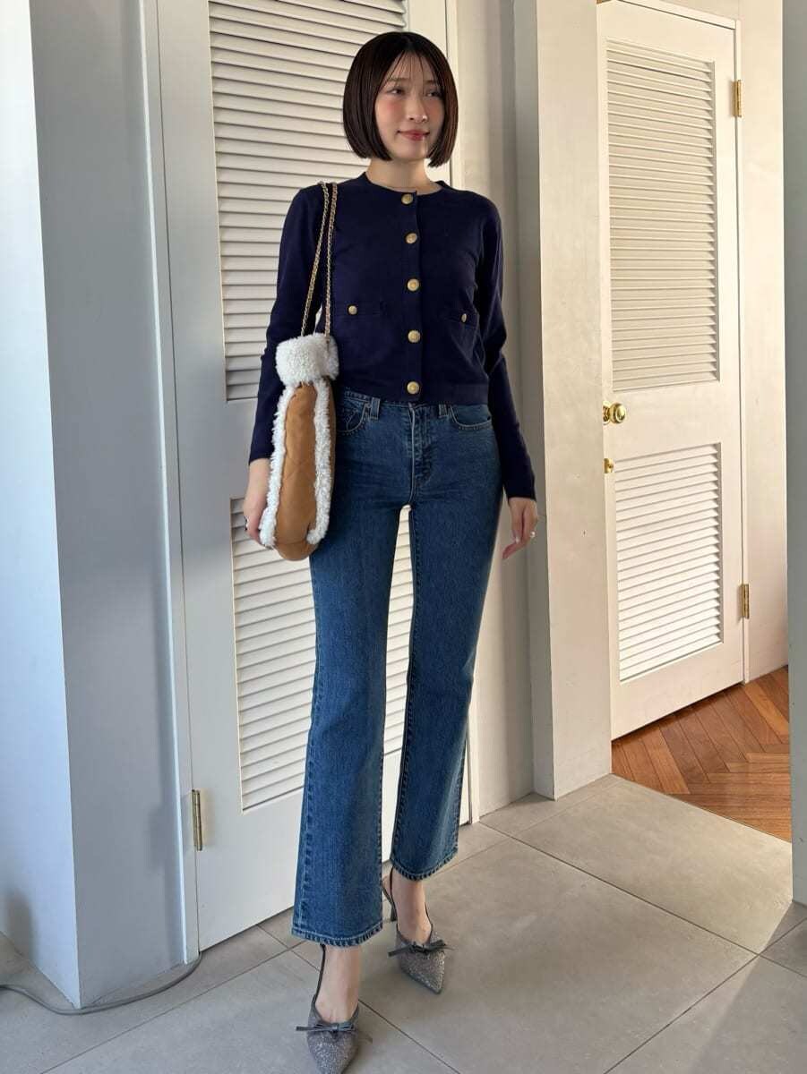 ブルー系のデニムパンツ、ブラウン系のハンドバッグを着用したレディースの秋コーディネートの7枚目の写真