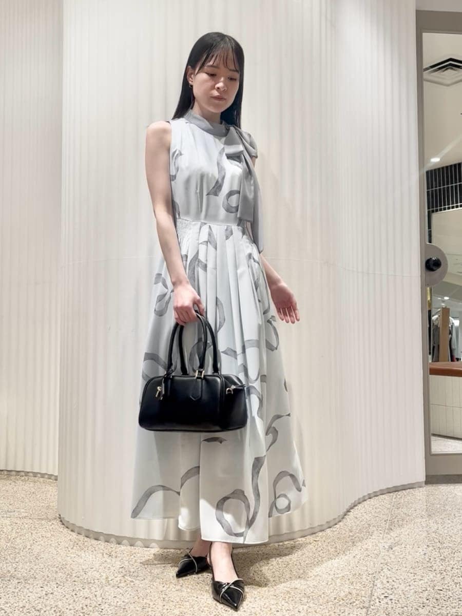 ブルー系のワンピース、ブラック系のパンプス、ブラック系のボストンバッグを着用したレディースの冬コーディネートの4枚目の写真