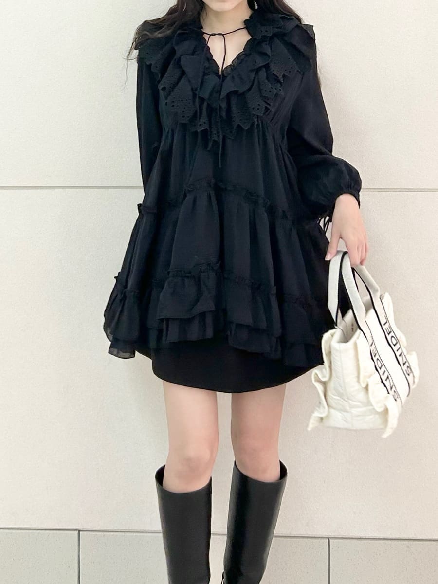 ブラック系のブーツ、ホワイト系のハンドバッグ、ブラック系のスカートを着用したレディースの冬コーディネートの5枚目の写真