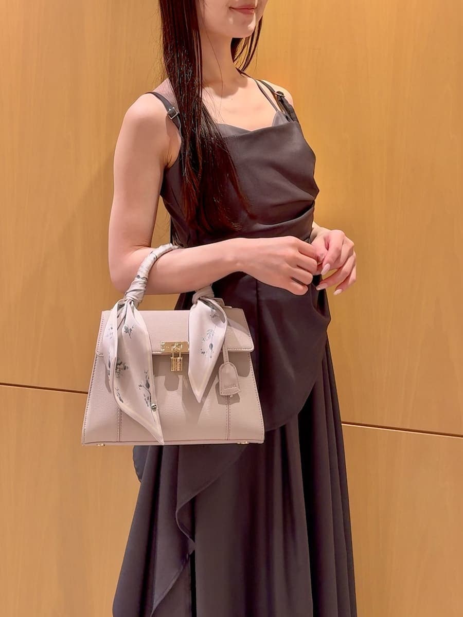 グレー系のワンピース、ブラック系のパンプス、ベージュ系のハンドバッグを着用したレディースの春コーディネートの8枚目の写真