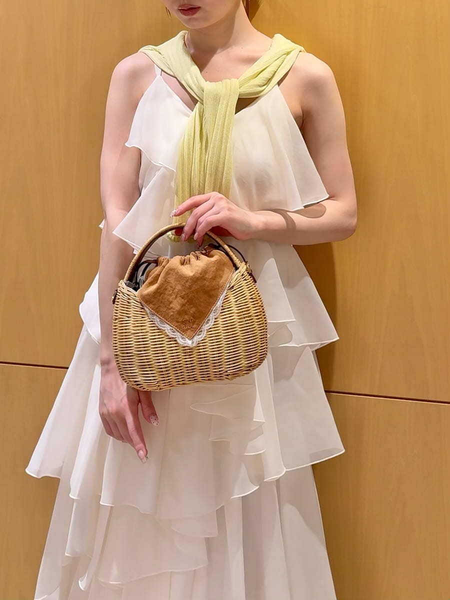 ブラウン系のかごバッグ、イエロー系のカーディガン/ボレロ、ホワイト系のドレスを着用したレディースの夏コーディネートの8枚目の写真