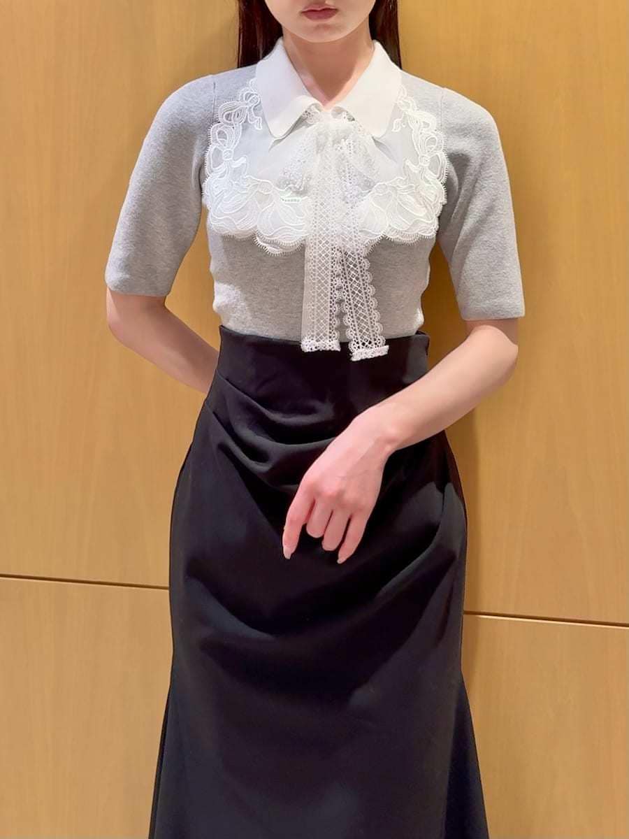 ブラック系のスカート、グレー系のニット/セーター、ホワイト系のハンドバッグを着用したレディースの春コーディネートの4枚目の写真