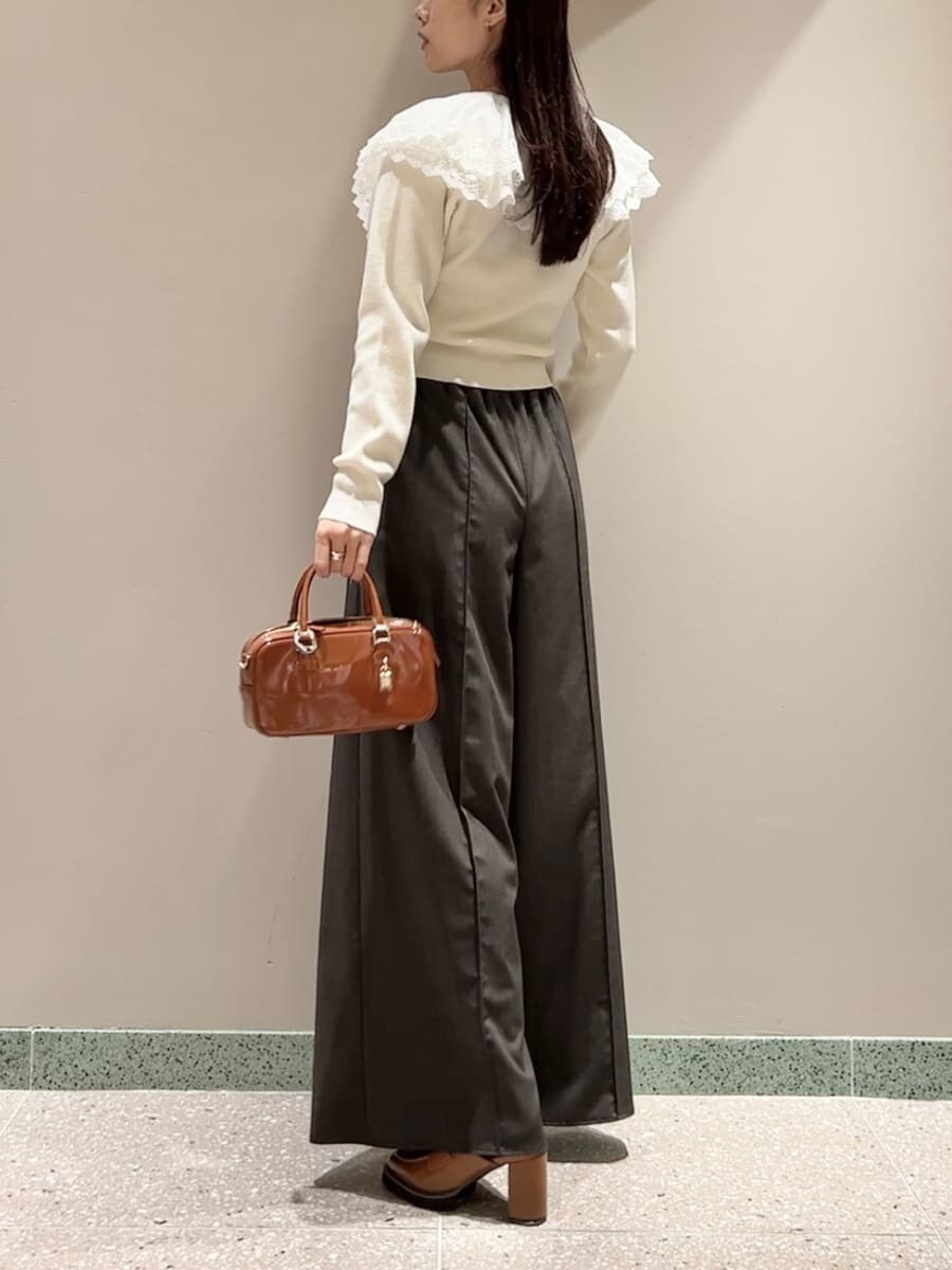 ホワイト系のニット/セーター、ブラウン系のその他パンツ、ブラウン系のボストンバッグを着用したレディースの秋コーディネートの3枚目の写真